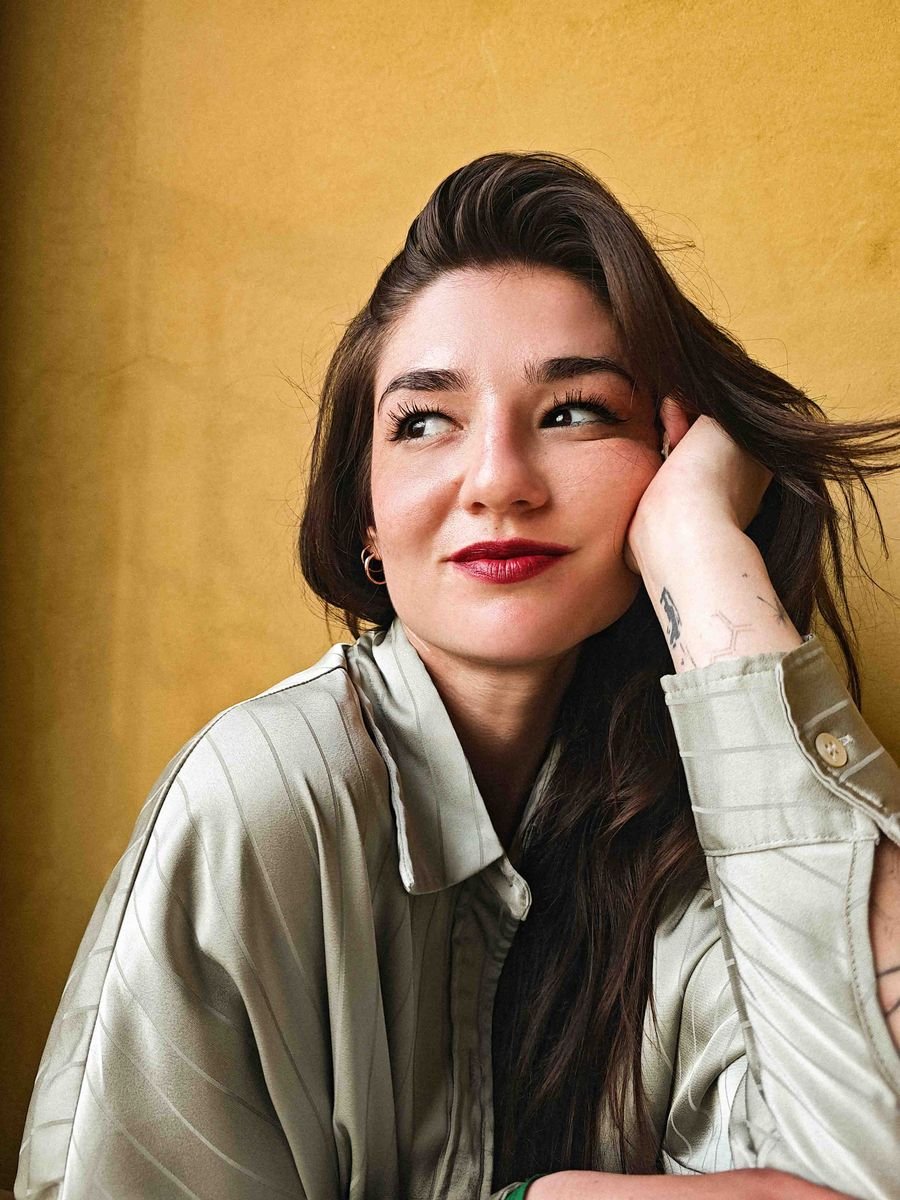 Smiling portrait of a model against a warm yellow wall