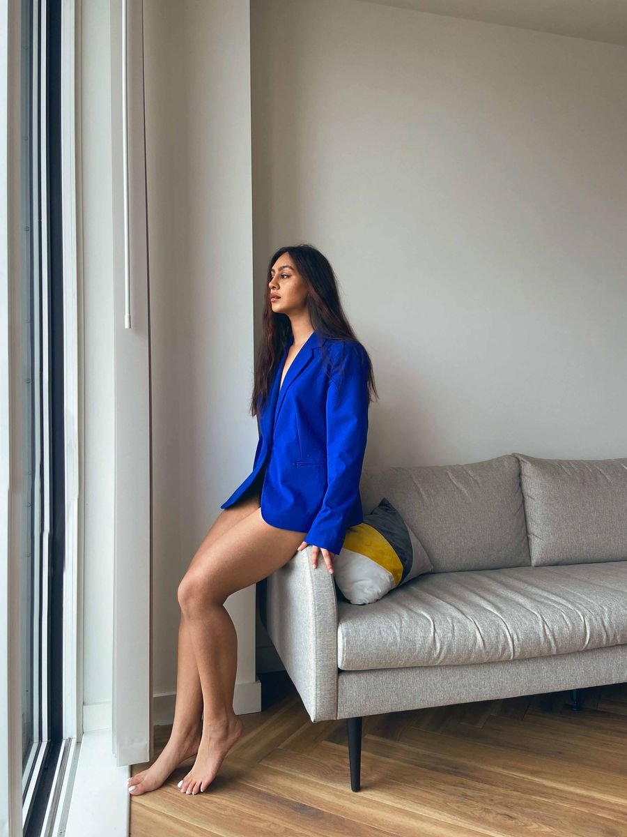 Wide shot of a model in a blue blazer in an ordinary living room