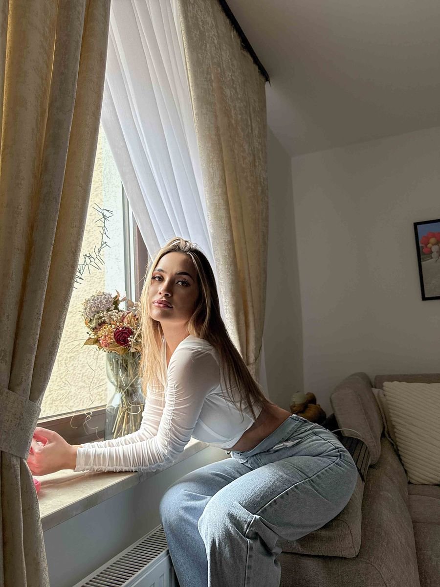 Relaxed portrait by a curtained window